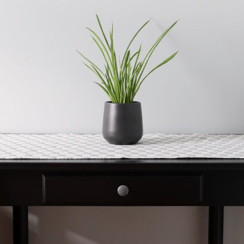 1. Table runner with Virumaa folk art pattern on dark wooden table with black plant pot