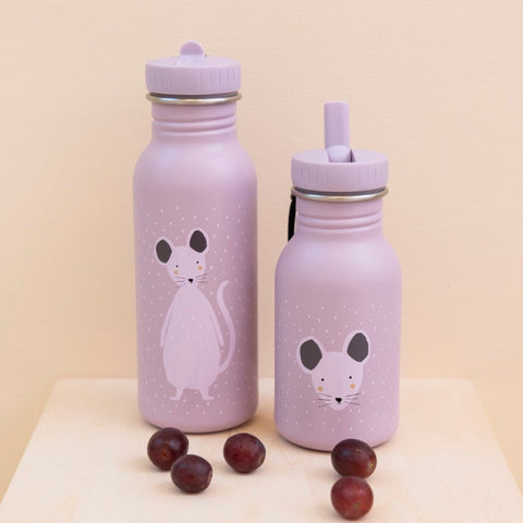 2. Two Trixie Baby Mrs Mouse stainless steel bottles on a wooden surface with grapes, showing different mouse designs