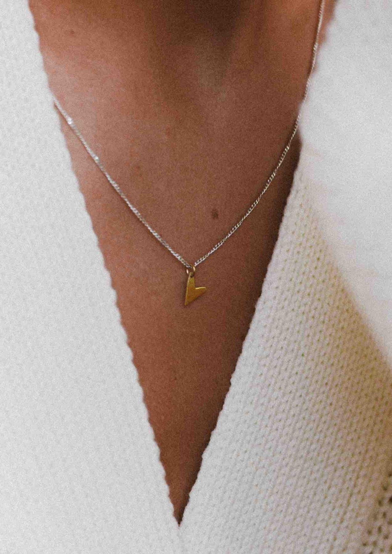 5. Love Necklace in gold by NO MORE, worn with a white knit top