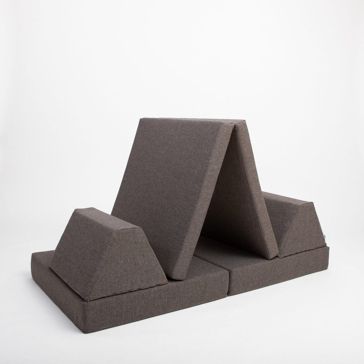 16. Monboxy dark brown play mattress set configured as a tent in a studio