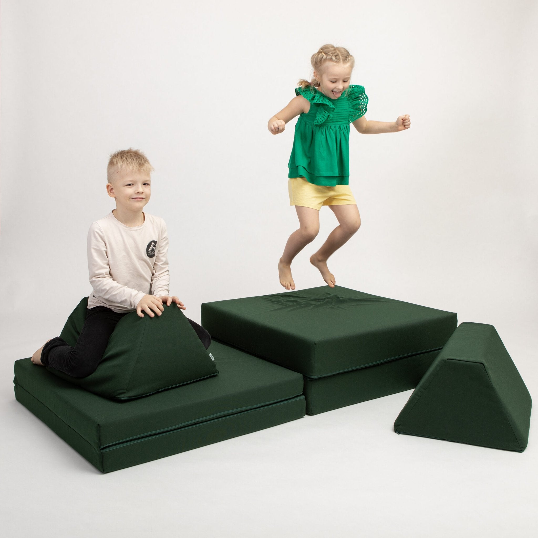 1. Two children playing on Monboxy deep green activity play mattress set in a studio setting