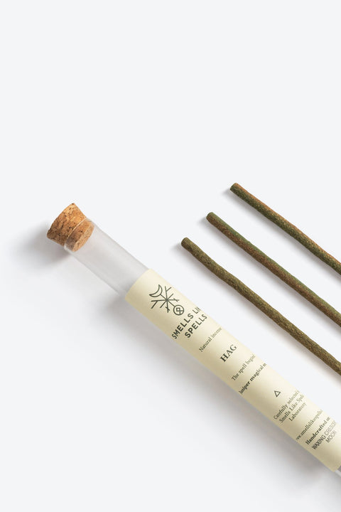 2. Close-up of Smells Like Spells Natural Incense HAG, featuring juniper sticks and branded glass tube