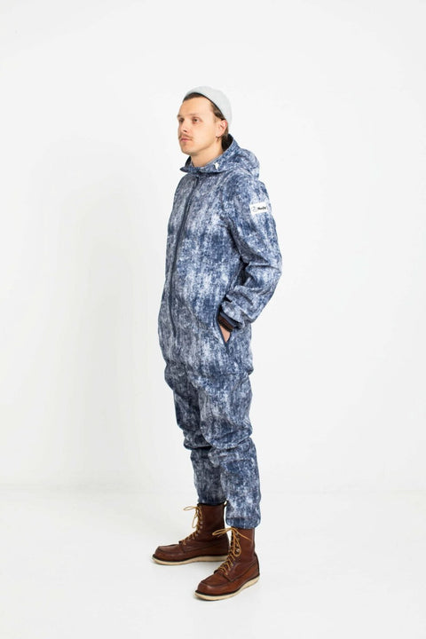 4. Man in Nuckö ERGO softshell overall with blue digital print, standing in studio, side view with hands in pockets