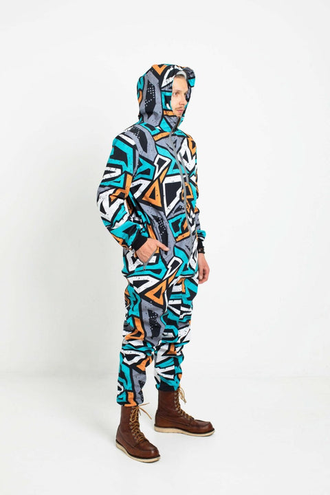 3. Man in Nuckö TANIEL softshell overall with hood up, hands in pockets, geometric design, studio setting