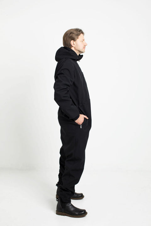 2. Side view of man in black Nuckö RÜNNO softshell overall with hood in studio