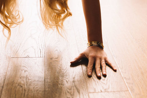3. Close-up of a woman's hand on the floor wearing Olla's MAAILMAN PARAS ĆITI bracelet in silver