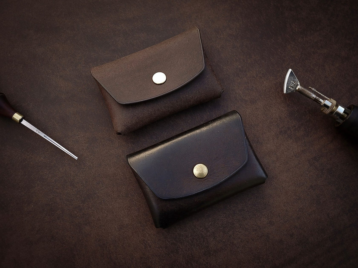5. Pair of Mirgoods dark brown button leather wallets, showcasing polished edges and brass snaps