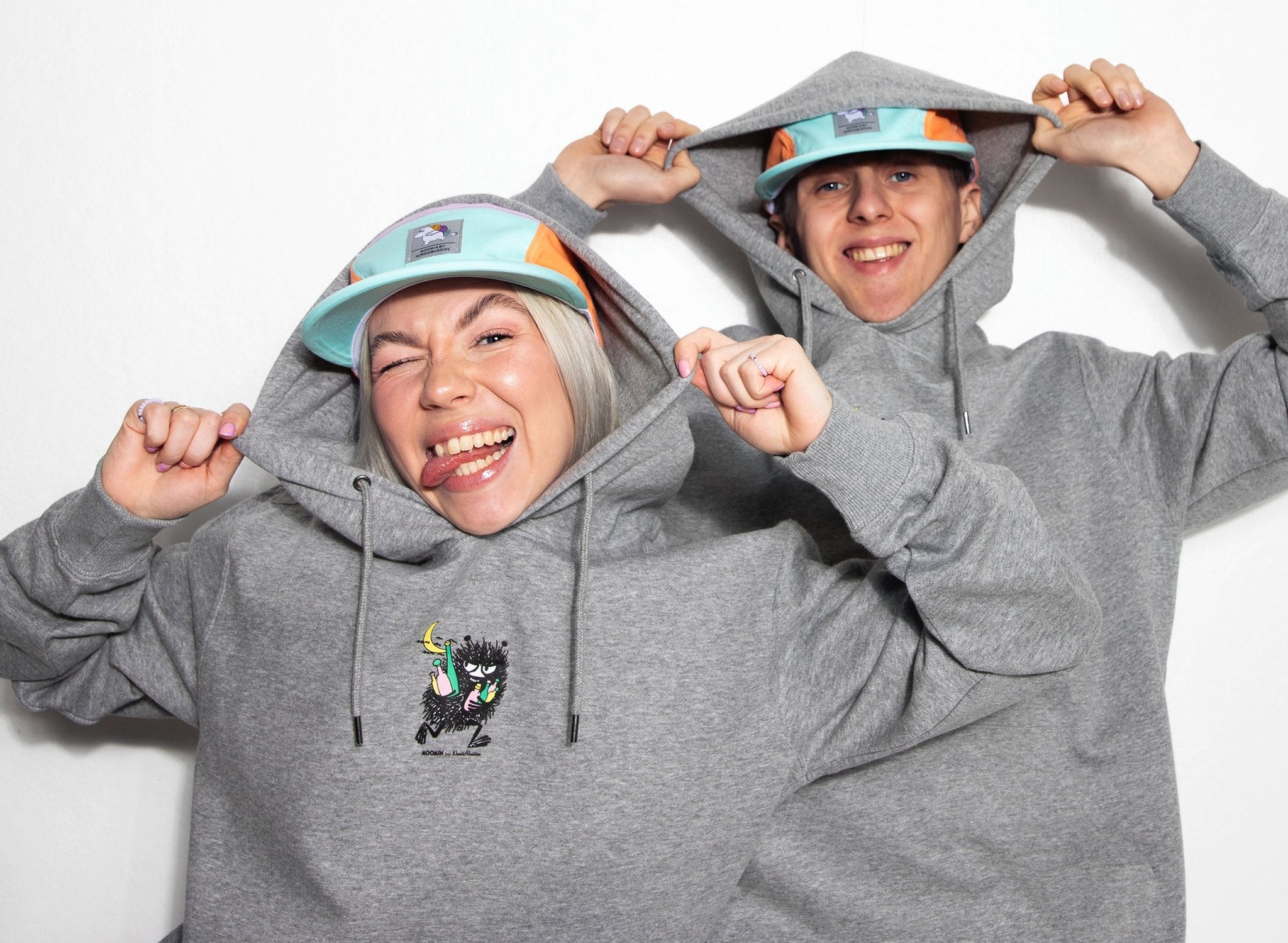 1. Unisex grey Moomin hoodie worn by male and female models, showcasing playful design