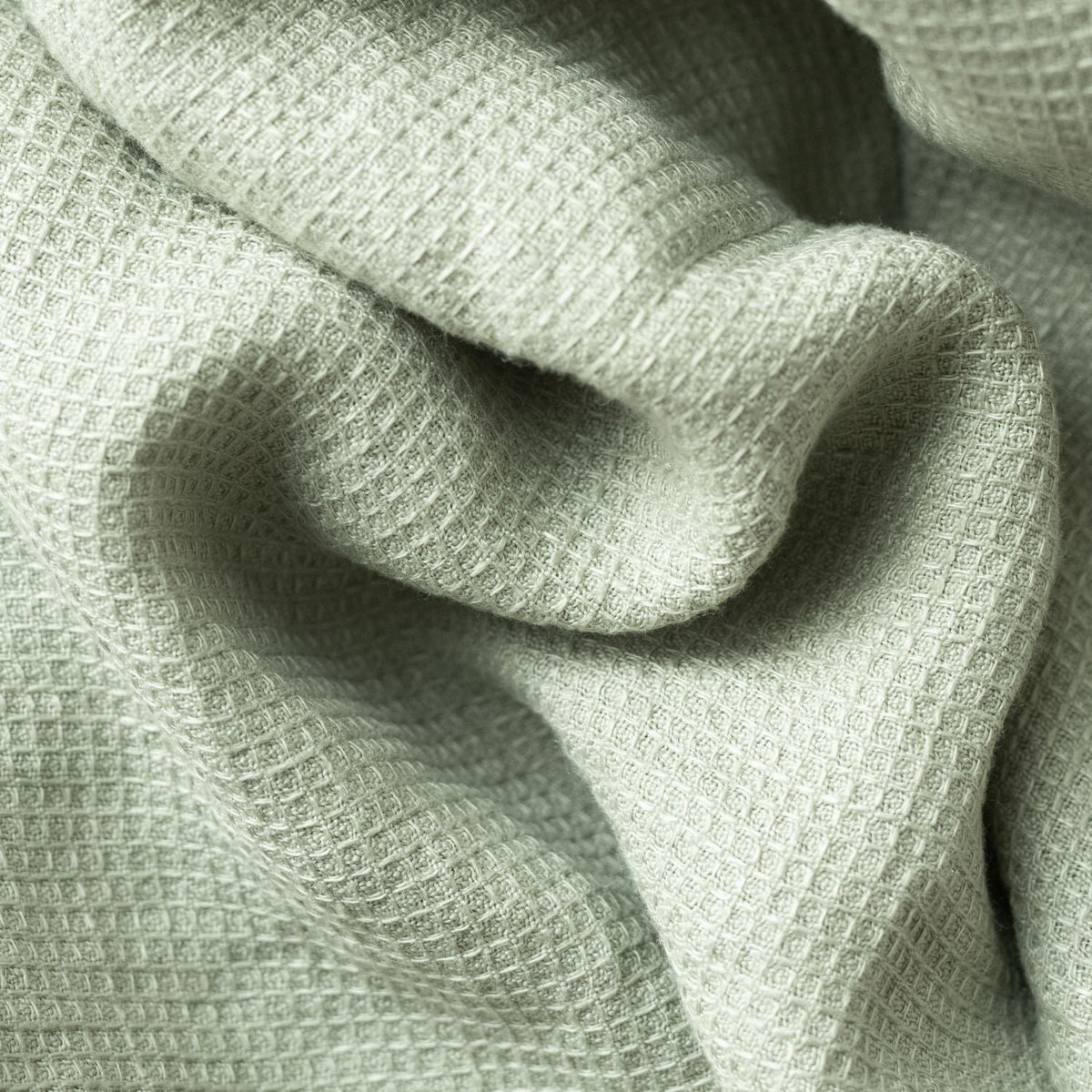 4. Detailed view of sage green waffle linen fabric highlighting texture and weave