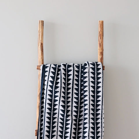 1. Black and white terry sauna towel with Saaremaa mitten pattern draped over wooden ladder against neutral wall