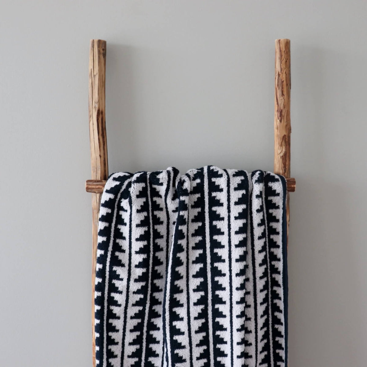 2. Close-up of black and white sauna towel featuring Saaremaa mitten pattern on wooden ladder