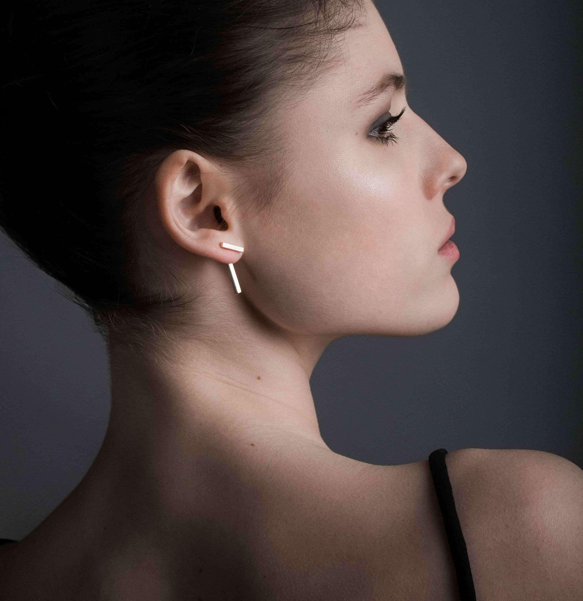 1. Woman wearing MyaMoon T-Bar Earrings in rose gold, showcasing Nordic minimalism