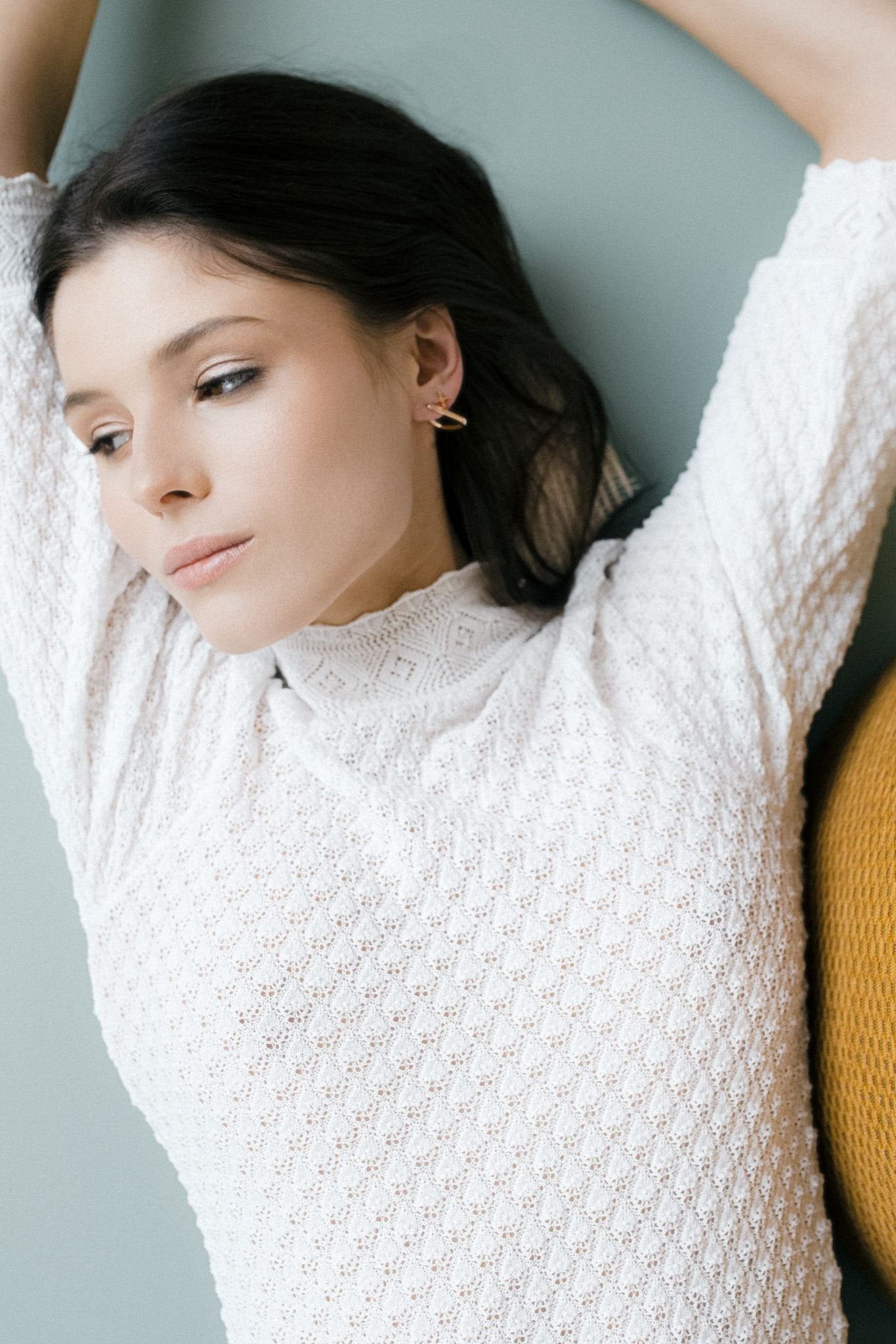 1. Woman wearing MyaMoon square hoop earrings in rose gold, styled with a white textured top, showcasing minimalist elegance
