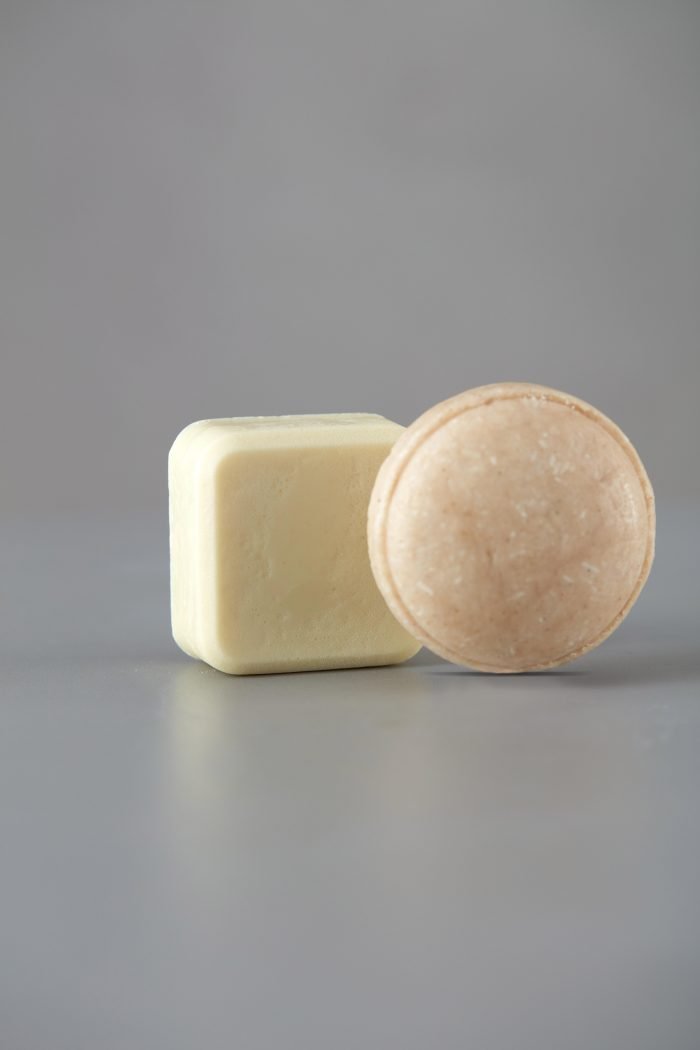 12. Woman lathering V.O.H solid shampoo in shower, back view