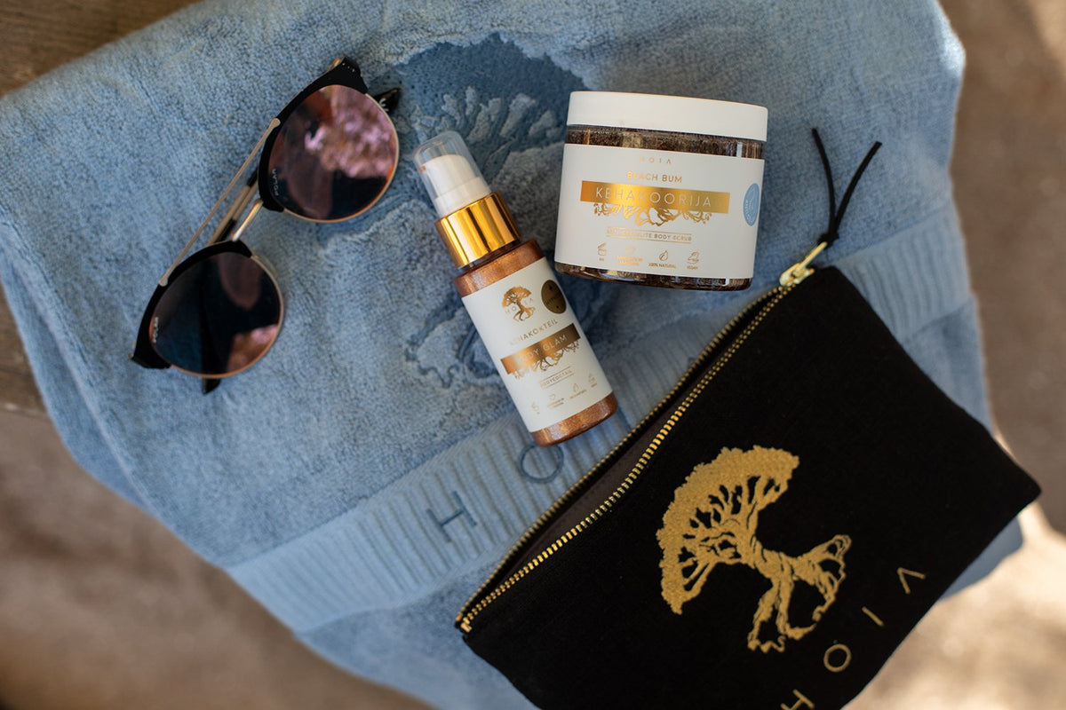 8. HOIA homespa Body Cocktail Body Glam with sunglasses and pouch, styled on blue towel