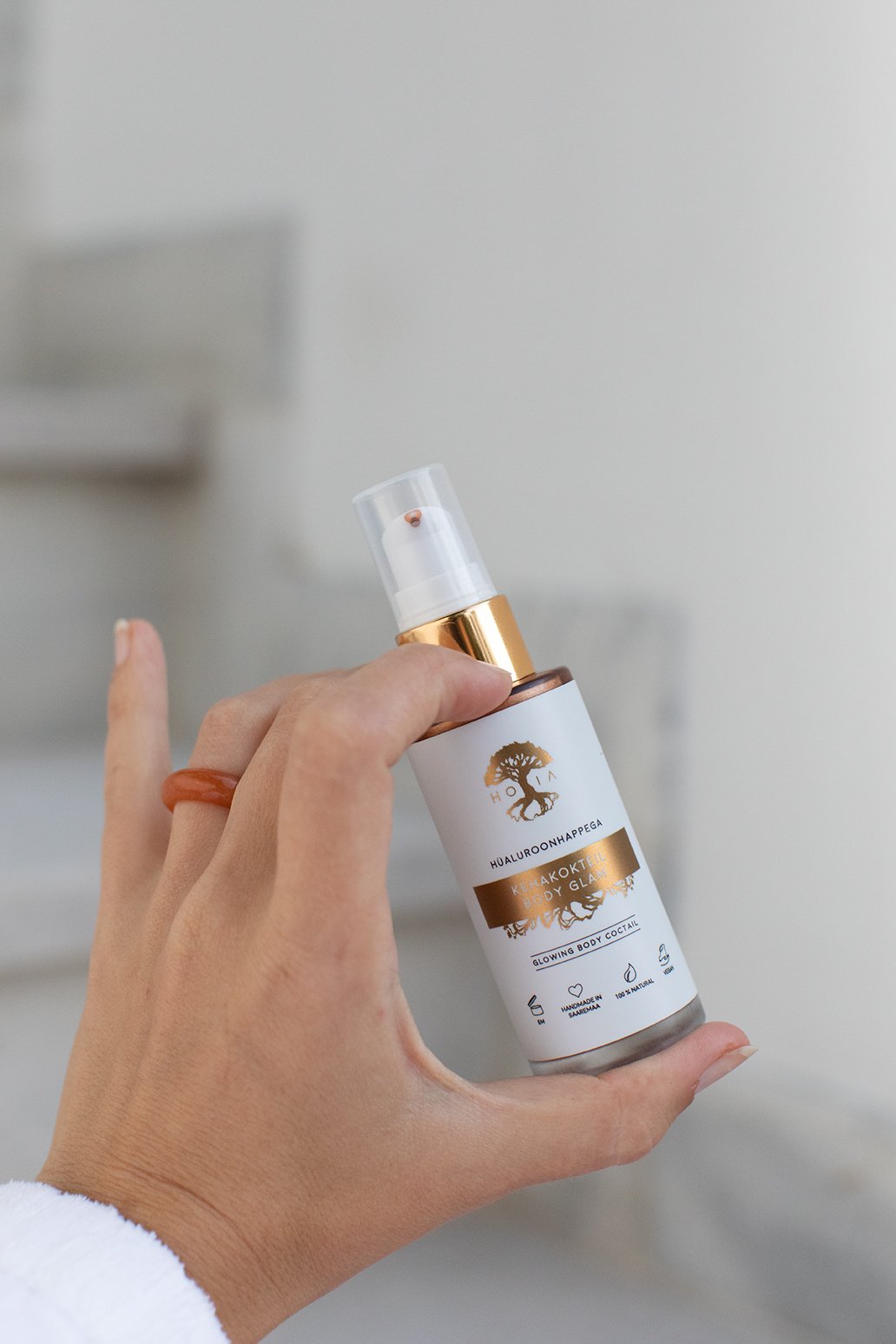 4. Woman holding HOIA homespa Body Cocktail Body Glam, showing product in hand