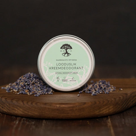 1. HOIA homespa cream deodorant with Saaremaa herbs in a tin, surrounded by lavender, on a wooden surface