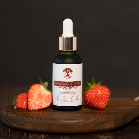 2. HOIA homespa Strawberry Seed Oil bottle with fresh strawberries on wooden board, studio setting