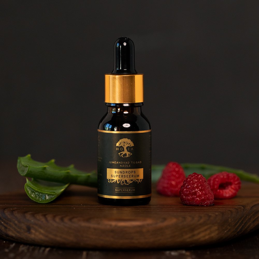 2. HOIA homespa Superserum Sundrops bottle with golden cap, styled with raspberries and aloe in lifestyle setting