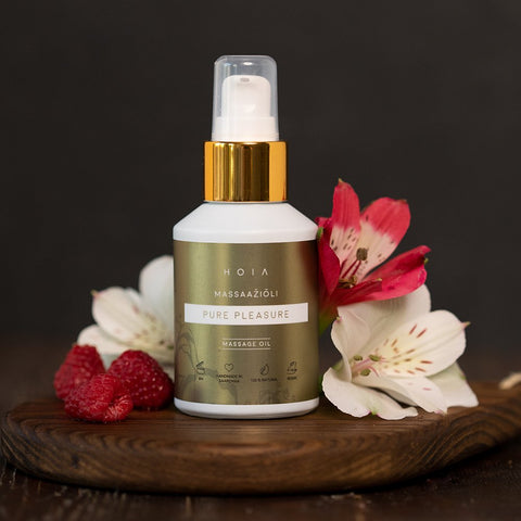 1. HOIA homespa Massage Oil Pure Pleasure 60ml bottle with gold cap, surrounded by flowers and raspberries, highlighting natural and organic ingredients