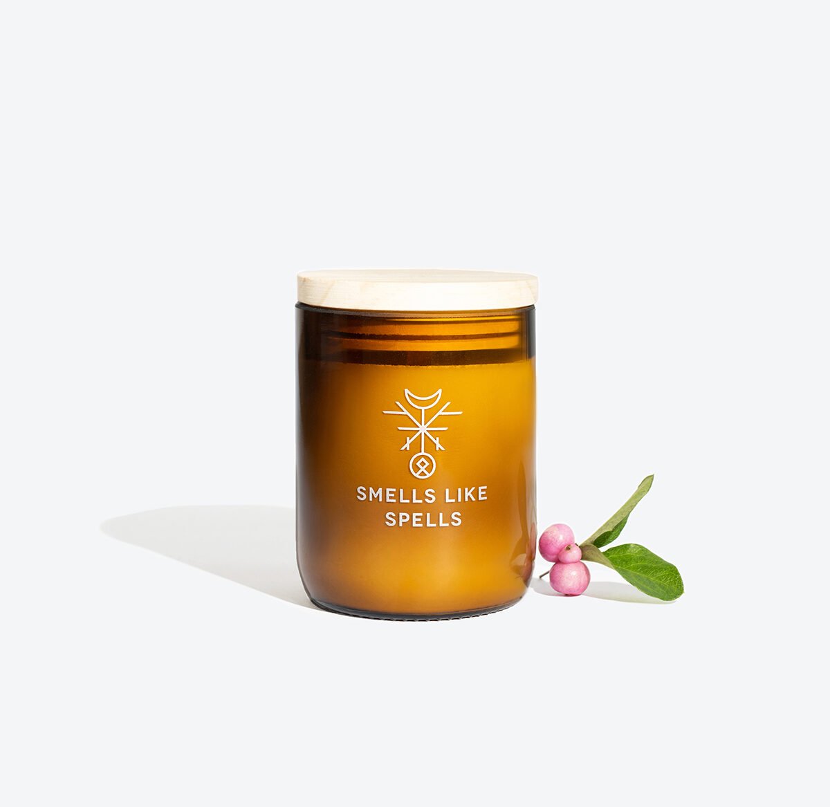 3. Smells Like Spells IDUNN scented candle in amber glass jar with decorative berries, studio shot