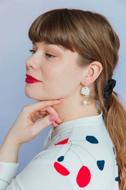 1. Woman wearing Rozenthal Arp Pearl and Porcelain Earrings in burgundy, showcasing elegant design