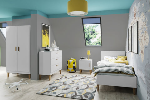 1. Kocot Kids Kubi white bedside table in a child's room with geometric rug and yellow accents
