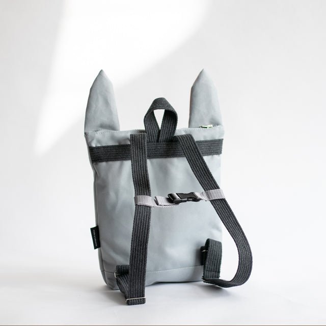 3. Girl sitting with Muni Bunny kids backpack, showing adjustable straps and playful design