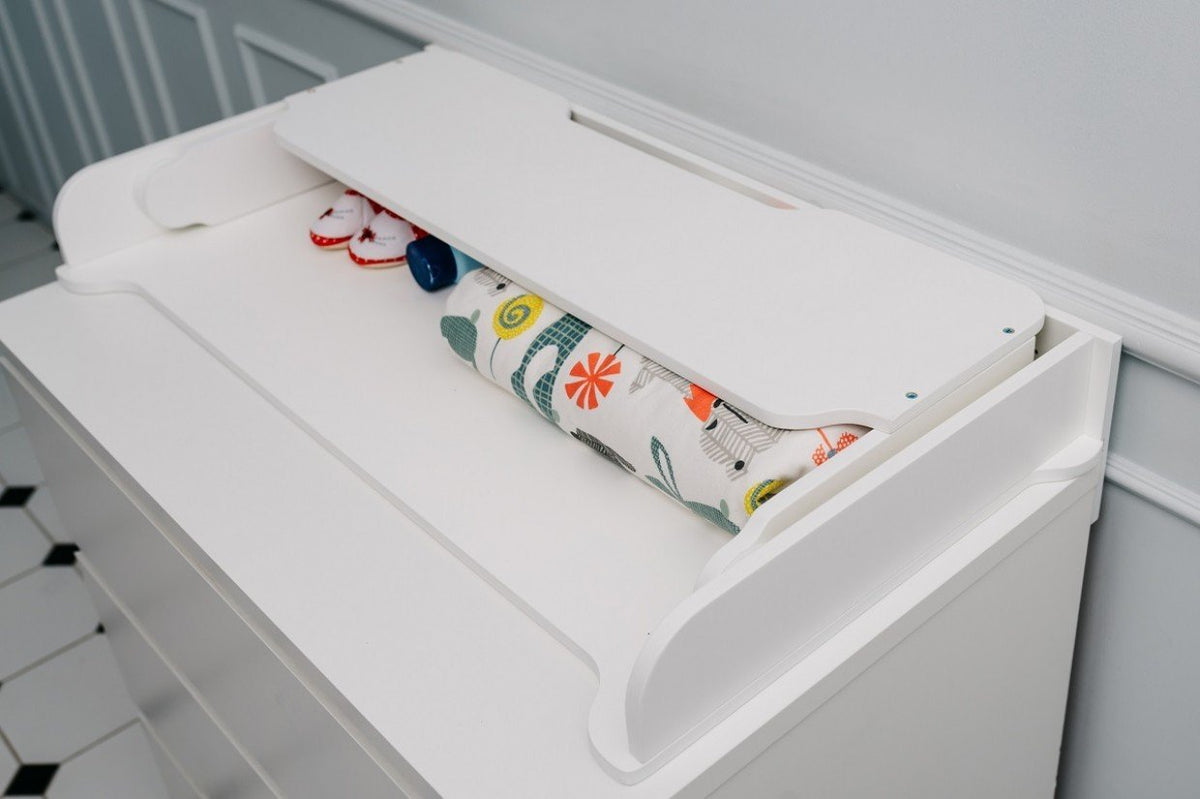 7. Close-up of white changing table top with colorful mat and baby essentials