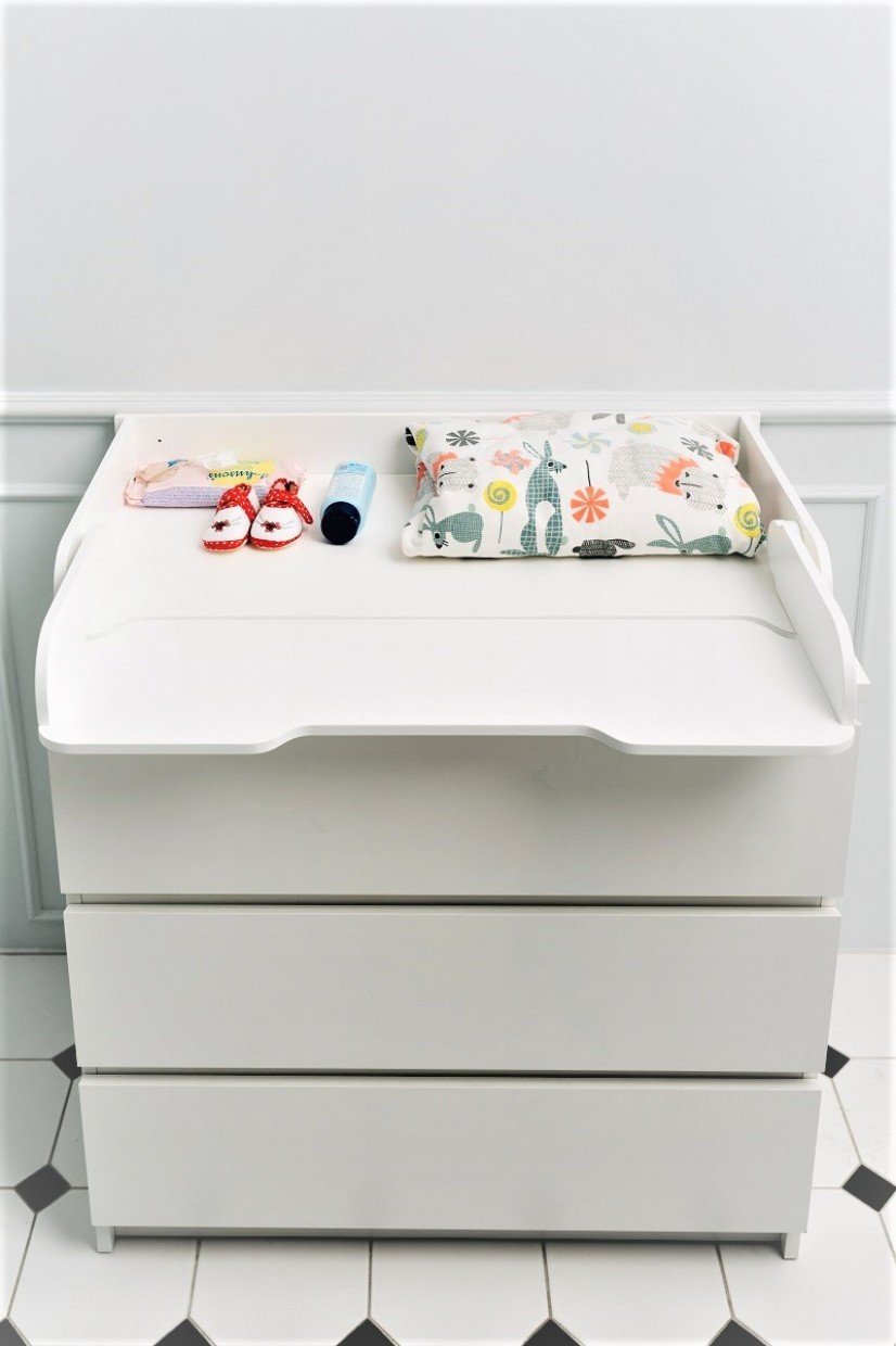 5. White changing table top with baby essentials on a chest of drawers in a nursery