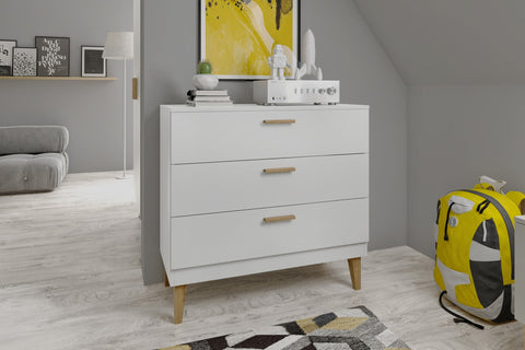 1. White chest of drawers with oak handles in a modern children's room with grey walls and a yellow backpack