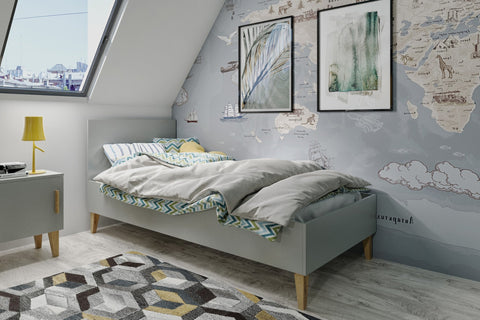 1. Grey Kubi bed in a child's room with world map wallpaper and geometric rug, creating a playful atmosphere