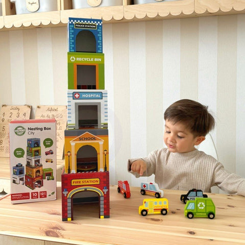 1. Young boy playing with colorful city-themed puzzle cubes and wooden vehicles on a wooden table
