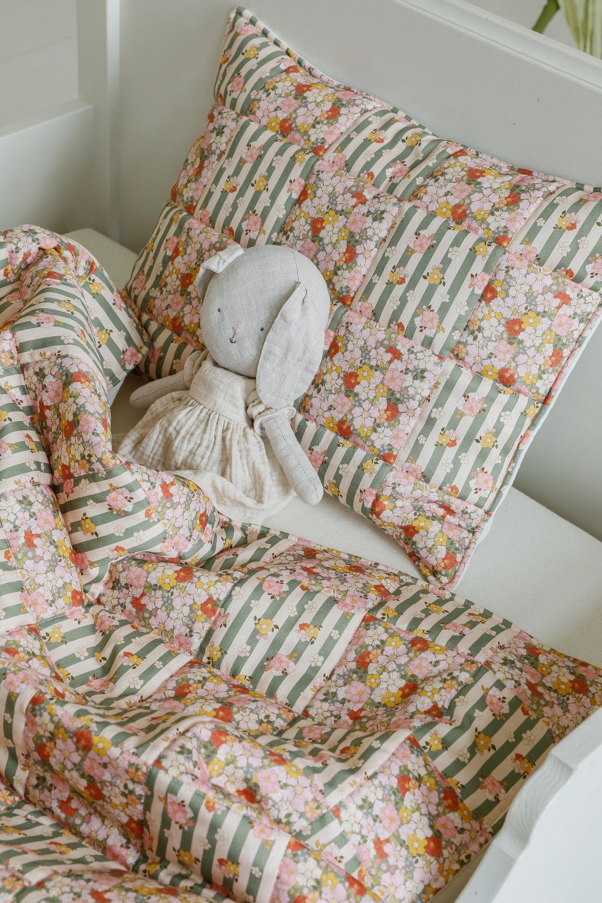 2. Cotton quilted patchwork blanket and pillow set with a stuffed toy on a bed