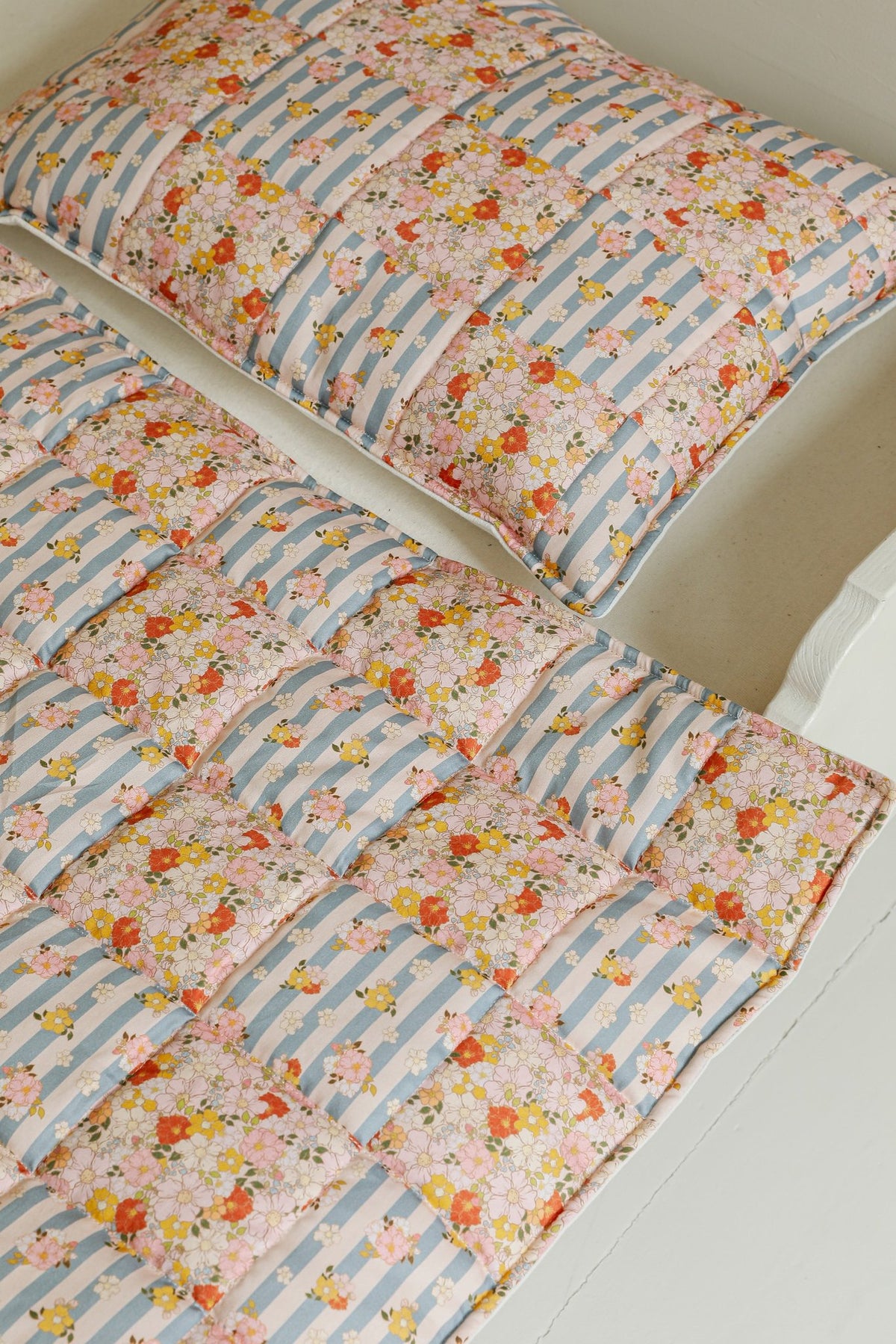 2. Cotton quilted patchwork blanket and pillow set with floral and striped design on bed