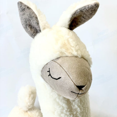 2. Studio shot of cream alpaca soft toy-pillow showing face and ears detail