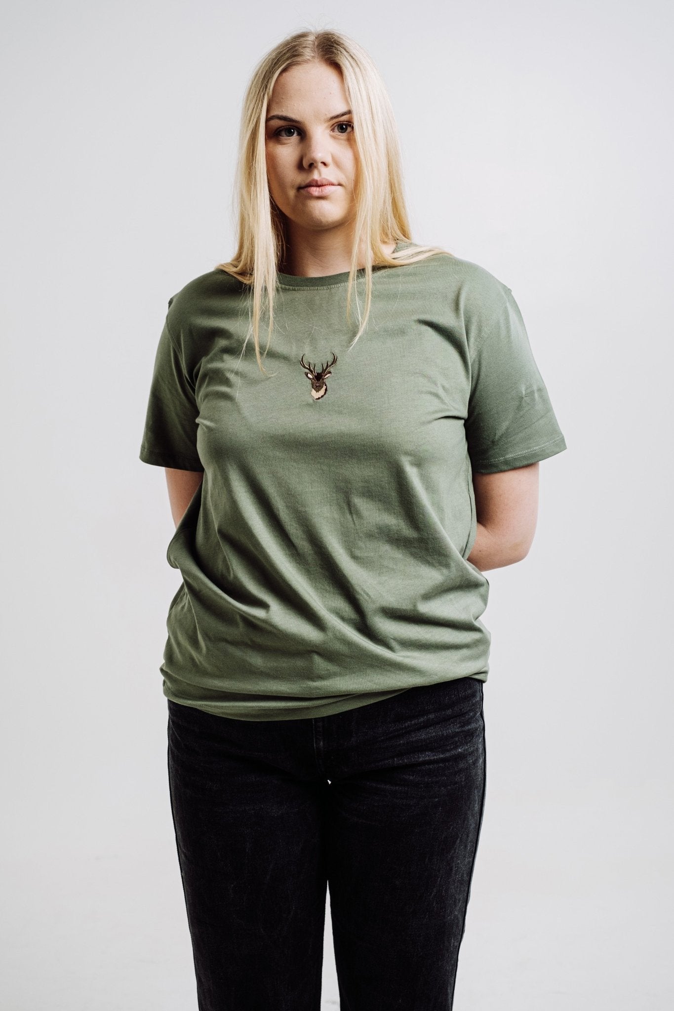 1. Unisex khaki Deer T-shirt by Sossu worn by female model in studio, showcasing relaxed fit and embroidered design