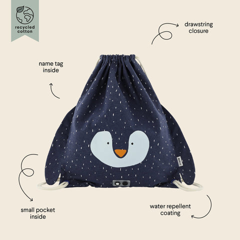 4. Flat lay of Trixie Baby's Mr. Penguin drawstring bag in navy with labeled features including drawstring closure, name tag, small pocket, and water repellent coating