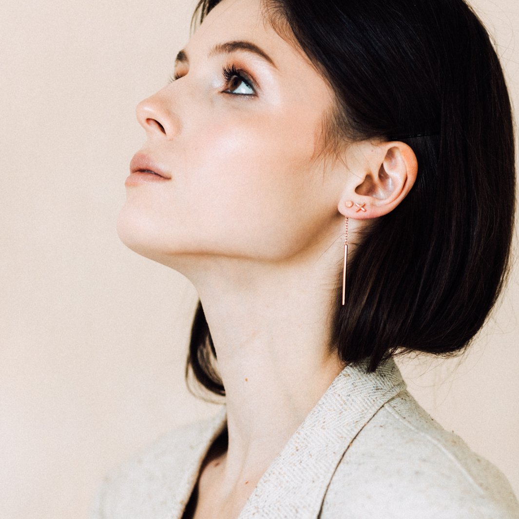 1. Woman wearing MyaMoon Dots Falling Earrings in rose gold, showcasing elegant long drop design