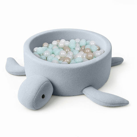 2. Turtle-shaped baby ball pit in dusty ice blue boucle fabric filled with pastel-colored balls, shown on a white background