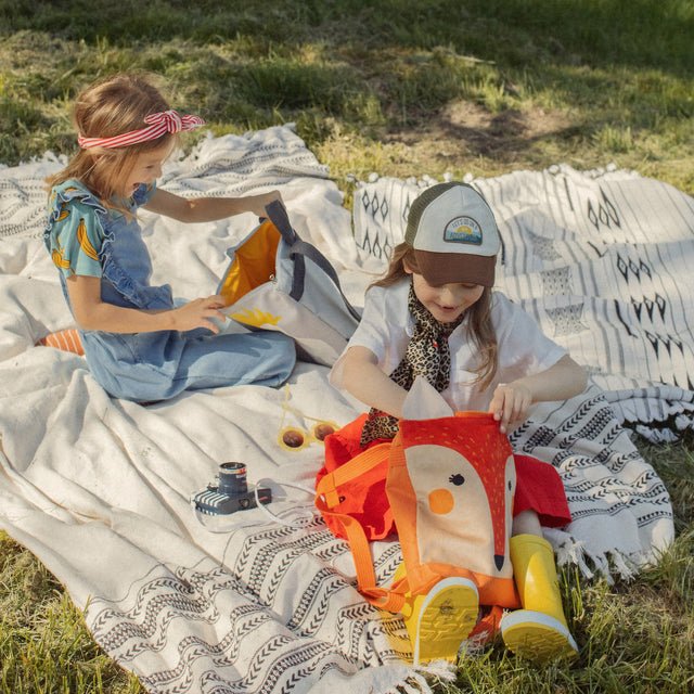 3. Children playing with Muni fox backpack in park, emphasizing fun and functionality