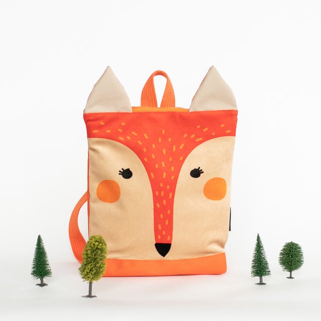 13. Muni kids fox backpack in studio with miniature trees, emphasizing nature-inspired theme