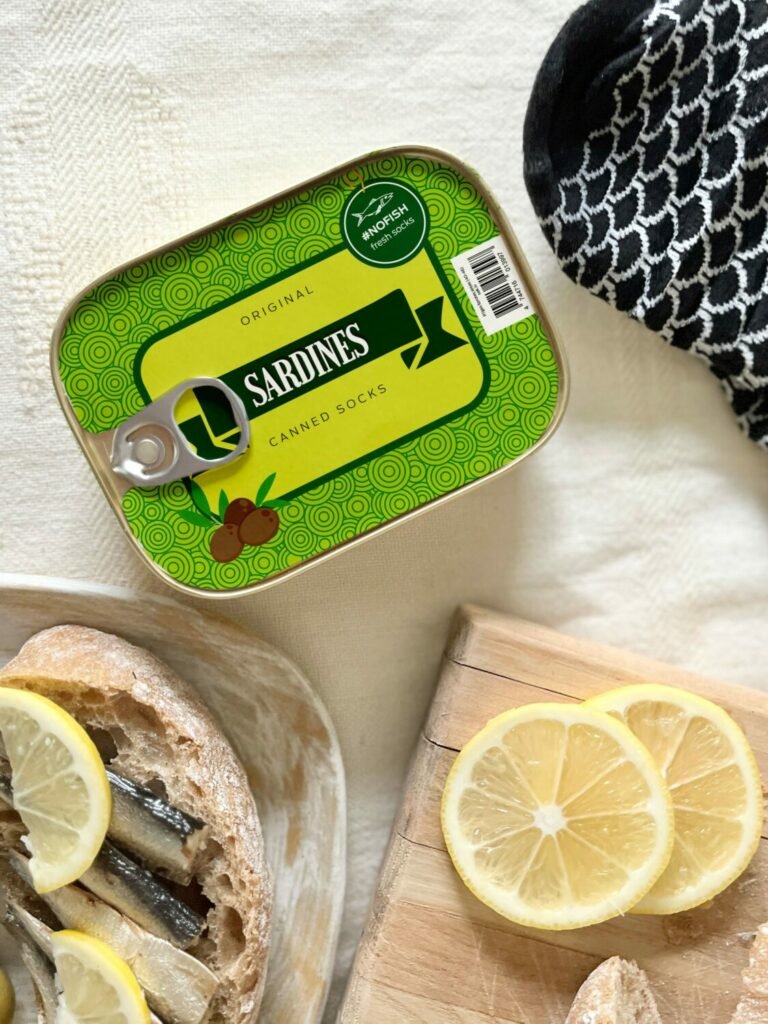 4. SEIK French Sardine Unisex Socks in a Can, unopened can with black and white socks, lifestyle setting