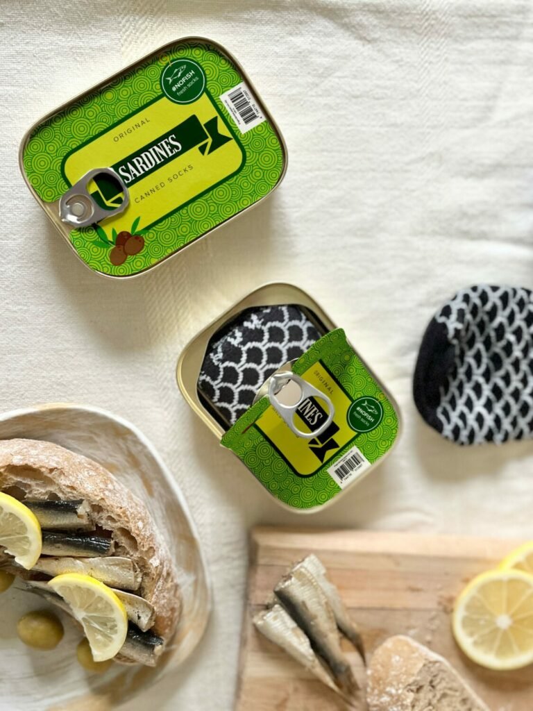 3. SEIK French Sardine Unisex Socks in a Can, black and white socks partially out of can, lifestyle setting