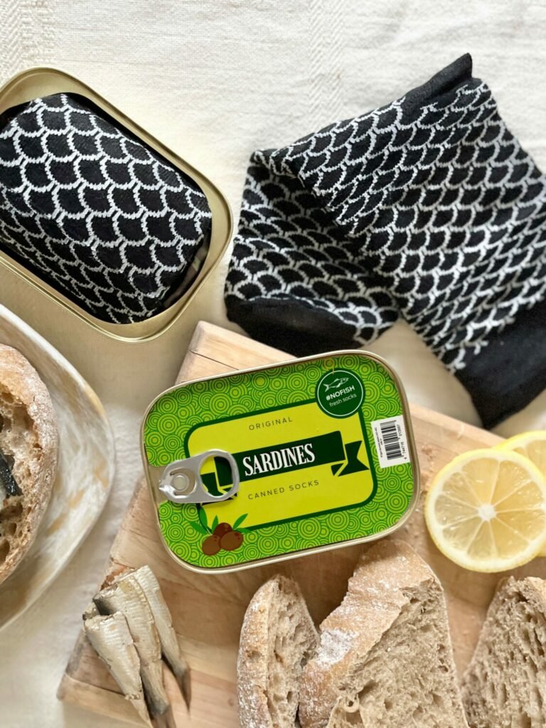 2. SEIK French Sardine Unisex Socks in a Can, black and white socks displayed with open can, lifestyle setting