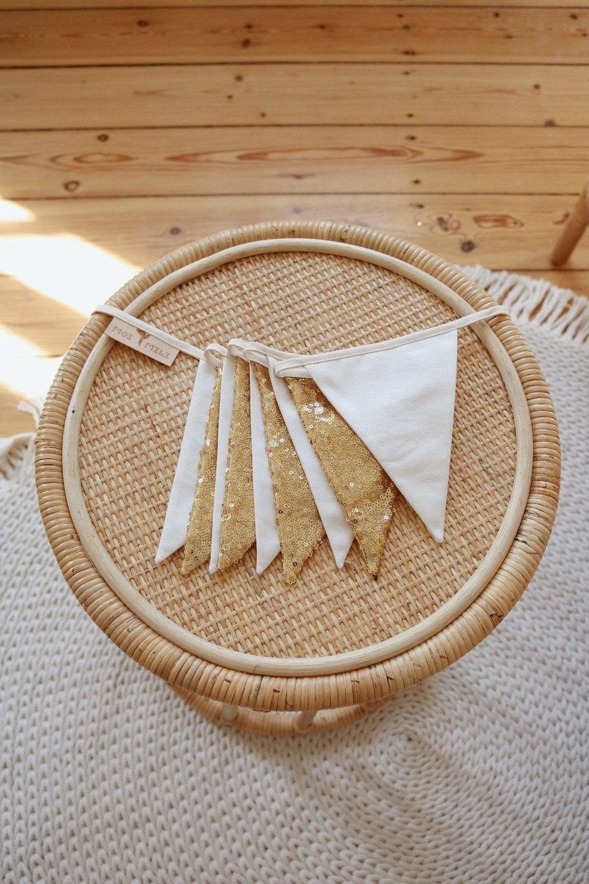 3. Close-up of gold and beige sequin garland on woven wicker surface