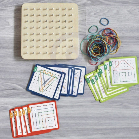 2. Woopie Green Geoplan set with wooden board, rubber bands, and pattern cards on grey wooden floor