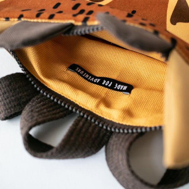 10. Interior view of Muni giraffe backpack, showing orange lining and zipper closure