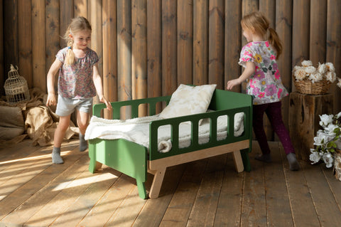 4. Two children playing near green growing bed in rustic wooden room