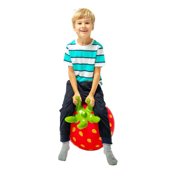 2. Boy in striped shirt sitting on red strawberry-shaped Jumpy toy with green handles on white background